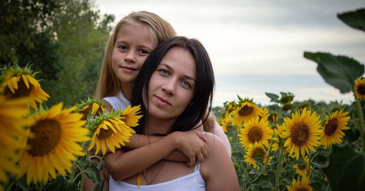 Mutter mit Kind im Sonnenblumenfeld